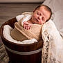 Bonnie a rejoint le concours — aidez-le/la à gagner de superbes lots ! newborn, baby, sleeping, wrapped, swaddled, wooden_bucket, blanket, lace, soft_texture, infant, cozy, peaceful, portrait, indoors, floor, wooden_floor, cute, resting, hands, wrapped_in_blanket