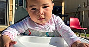 Lovella joined the competition — help win amazing prizes! baby, child, highchair, pink_onesie, outdoor, sunlight, concentration, face, hands, plastic, chair, patio, house, door, window, shadow, red_chair, person, infant, daylight