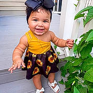 Galileia joined the competition — help win amazing prizes! toddler, child, smiling, yellow_top, sunflower_dress, headband, bow, outdoor, porch, plants, greenery, white_sandals, happy, cute, baby, feet, jewelry, bracelet, necklace, summer