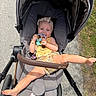 Kataleya is registered to the contest to win money with this photo: baby, stroller, child, toy, outdoor, sunflower, headband, blue_eyes, playful, kicking, gray, pavement, grass, sunny, footwear, blanket, happy, person, summer, casual