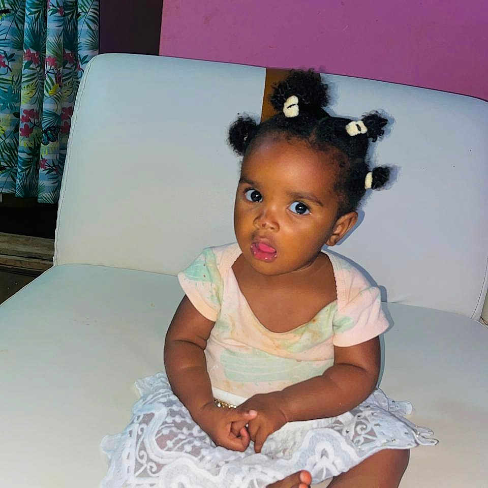 Lumaria Kiazi participe au concours pour gagner de l'argent avec cette photo : baby, child, curly_hair, curtains, cute, expression, face, furniture, hair_puffs, indoor, lace_skirt, pastel_clothing, person, pink_wall, portrait, sitting, toddler, white_couch, wooden_floor, young_child