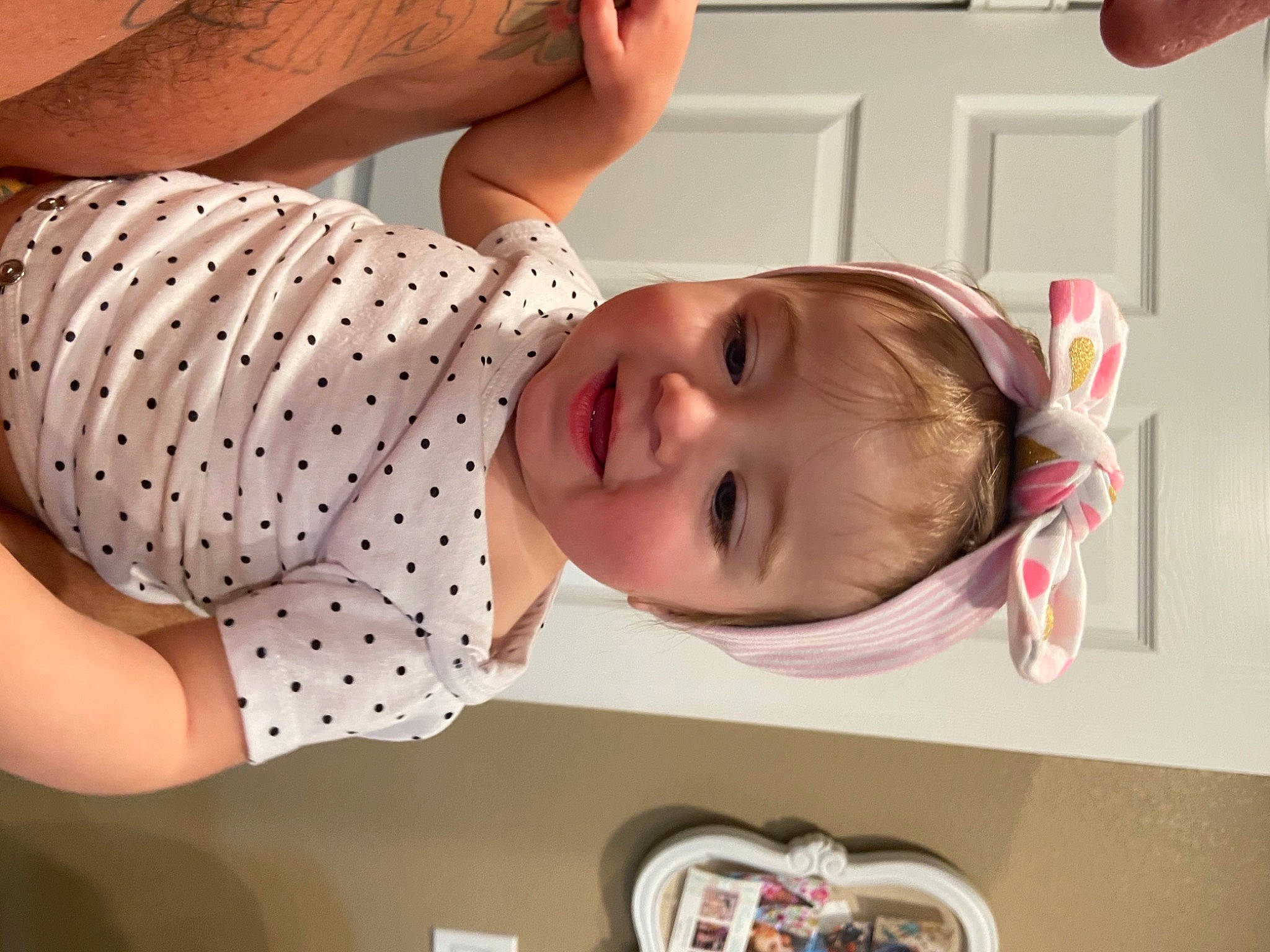 Lily is registered to the contest to win money with this photo: arm, baby, baby_products, baby_toddler_clothing, cheek, child, eyelash, finger, fun, gesture, happy, mouth, pattern, person, photograph, pink, skin, sleeve, smile, toddler