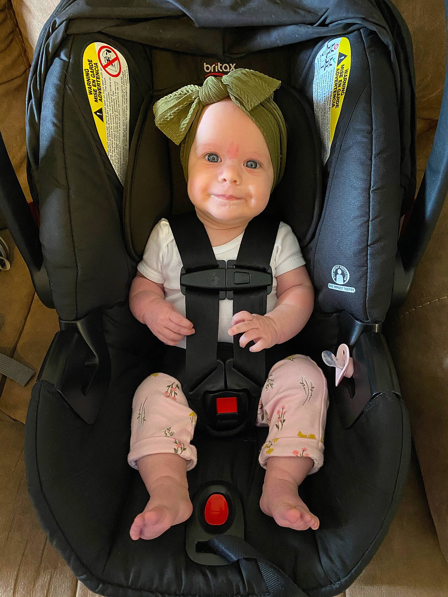 Amelia is registered to the contest to win money with this photo: auto_part, baby, baby_carriage, baby_in_car_seat, baby_products, baby_toddler_clothing, bag, black, car_seat, child, comfort, face, fun, head, headwear, person, personal_protective_equipment, service, sitting, smile
