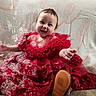 baby, blanket, bubbles, celebration, child, clothing, couch, cute, fabric, face, footwear, happy, indoor, infant, joy, portrait, red_dress, sitting, smile, sparkle