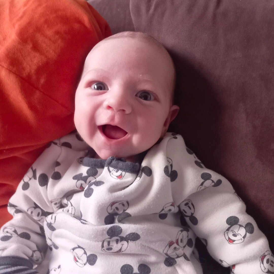 Léo participe au concours pour gagner de l'argent avec cette photo : baby, babylaughing, blanket, bodypart, clothing, couch, cushion, face, furniture, happy, head, homedecor, laughing, mouth, newborn, pajamas, person, photography, portrait, smile