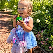 Halstyn joined the competition — help win amazing prizes! toddler, child, outdoor, sunny, greenery, flowers, pretzel, ball, blue_tutu, pink_purse, stuffed_animal, hair_tied, cute, walking_path, nature, daylight, shoes, playful, garden, portrait