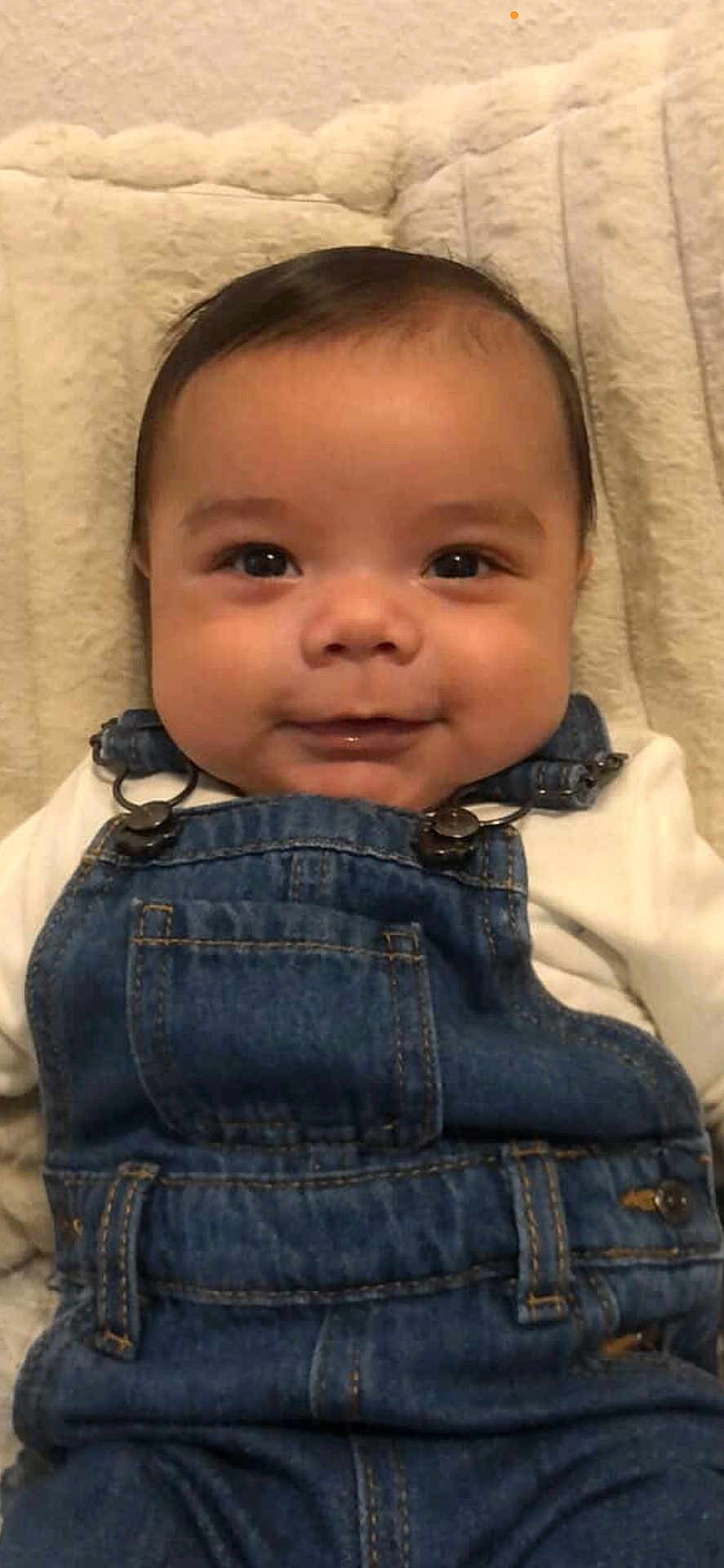 Elyam a rejoint le concours — aidez-le/la à gagner de superbes lots ! baby, infant, smile, smiling, denim_overalls, overalls, portrait, close_up, face, cheeks, eyes, hair, blanket, soft_fabric, cute, clothing, indoor, lying_down, happy, adorable