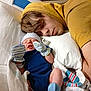 Secil is registered to the contest to win money with this photo: baby, bed, blanket, cozy, cute, face, family, hospital, indoor, infant, man, mittens, newborn, person, pillow, resting, sleeping, socks, striped, yellow_hoodie