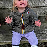 Joséphine a rejoint le concours — aidez-le/la à gagner de superbes lots ! toddler, child, smile, laughing, jacket, boots, bench, outdoor, grass, wood, nature, person, happy, clothing, pants, face, hair, sitting, expression, park
