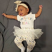 Azari joined the competition — help win amazing prizes! arms_outstretched, baby, bow, child, clothing, cute, grey_background, happy, headband, indoor, infant, leggings, lying_down, person, playful, portrait, smiling, toddler, tulle_skirt, white_socks