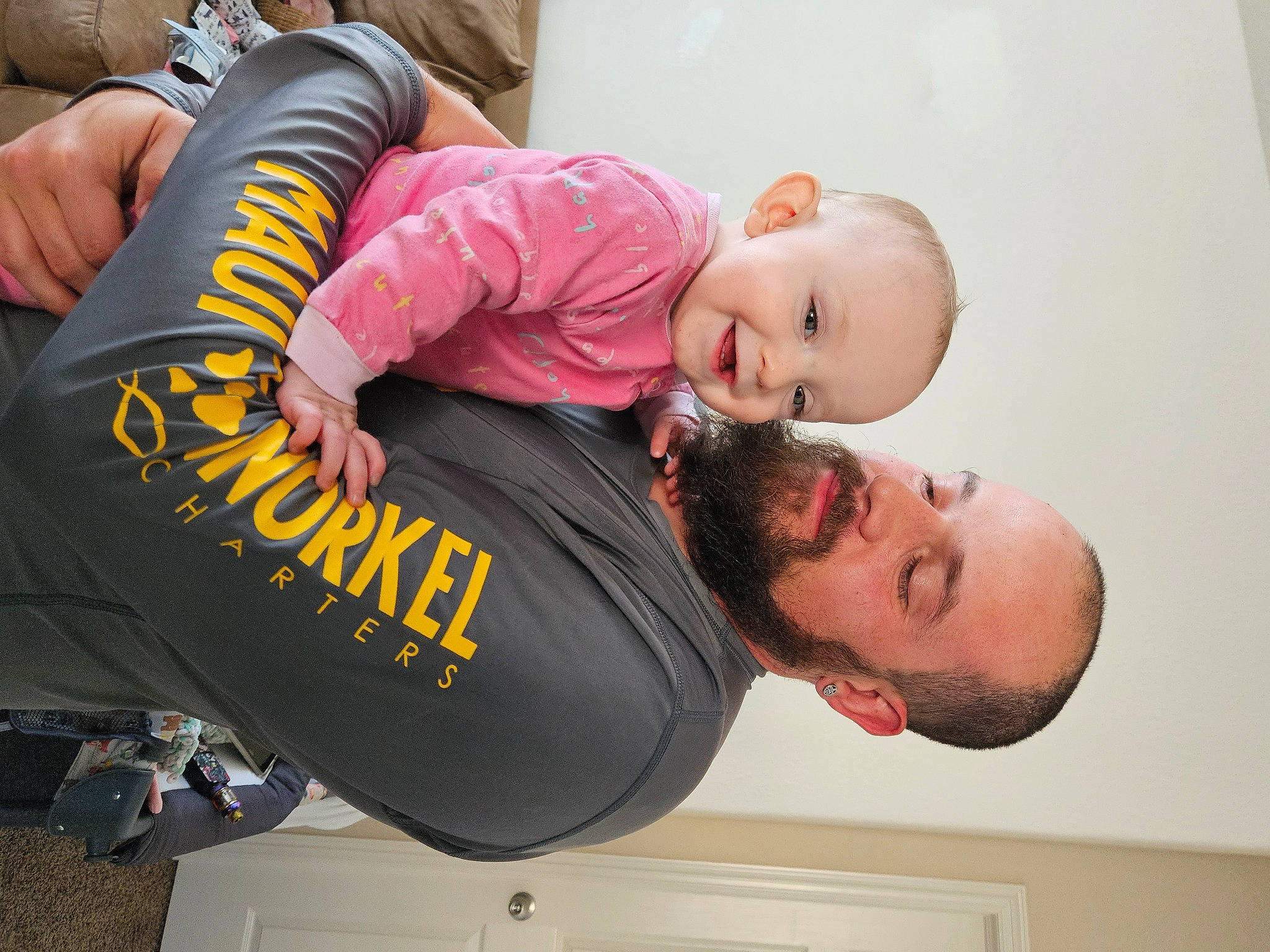 Mckenzie is registered to the contest to win money with this photo: baby, baby_products, baby_toddler_clothing, child, comfort, elbow, fun, gesture, happy, joint, joy, person, room, sleeve, smile, sock, t_shirt, toddler