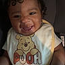 baby, child, smiling, curly_hair, bib, winnie_the_pooh, car_seat, happy, infant, clothing, portrait, cute, person, seat, indoor, young_child, face, baby_clothes, joy, young