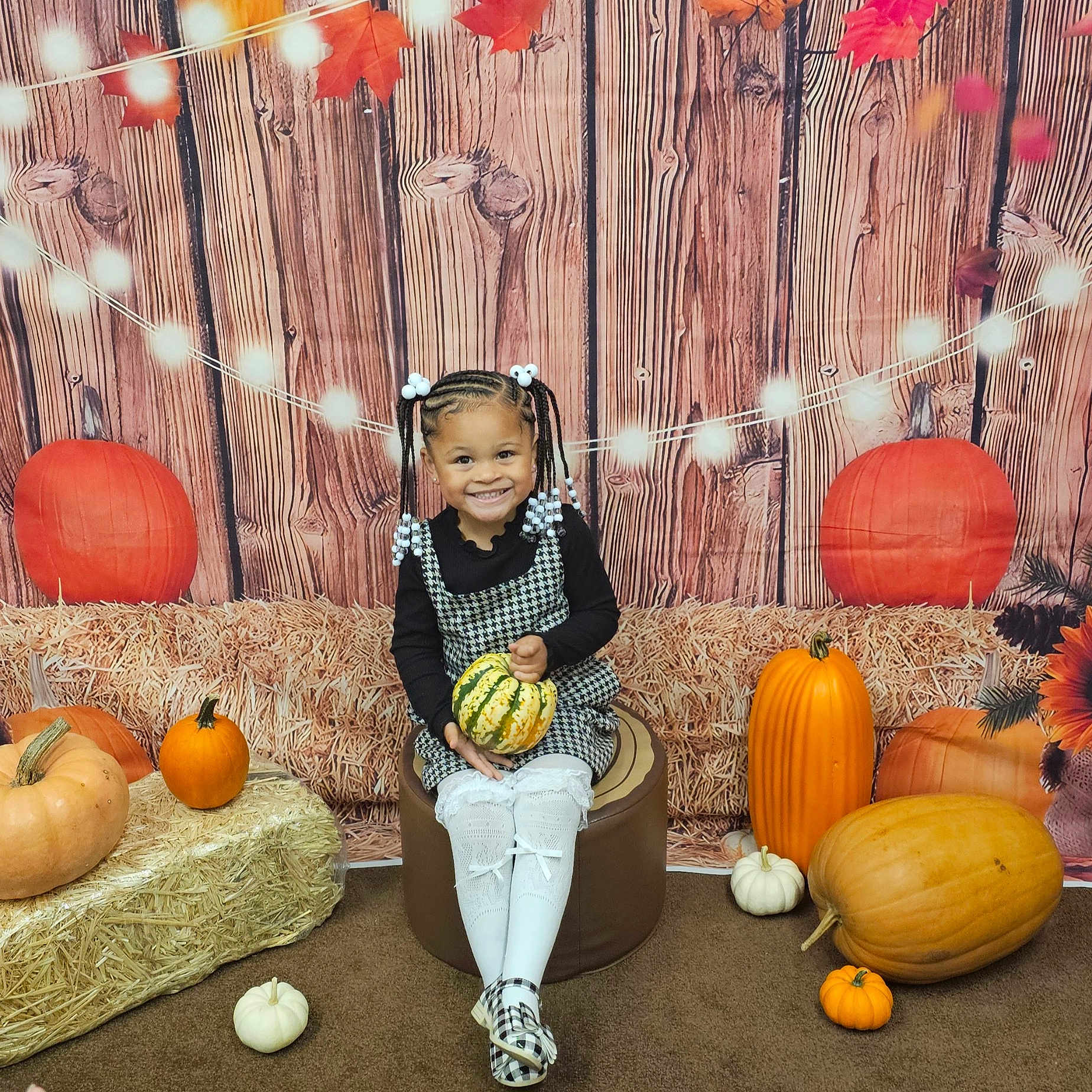 An'Drina is registered to the contest to win money with this photo: child, clothing, face, female, festival, food, footwear, girl, halloween, head, jack_o_lantern, person, plant, produce, pumpkin, racket, sandal, sitting, squash, vegetable