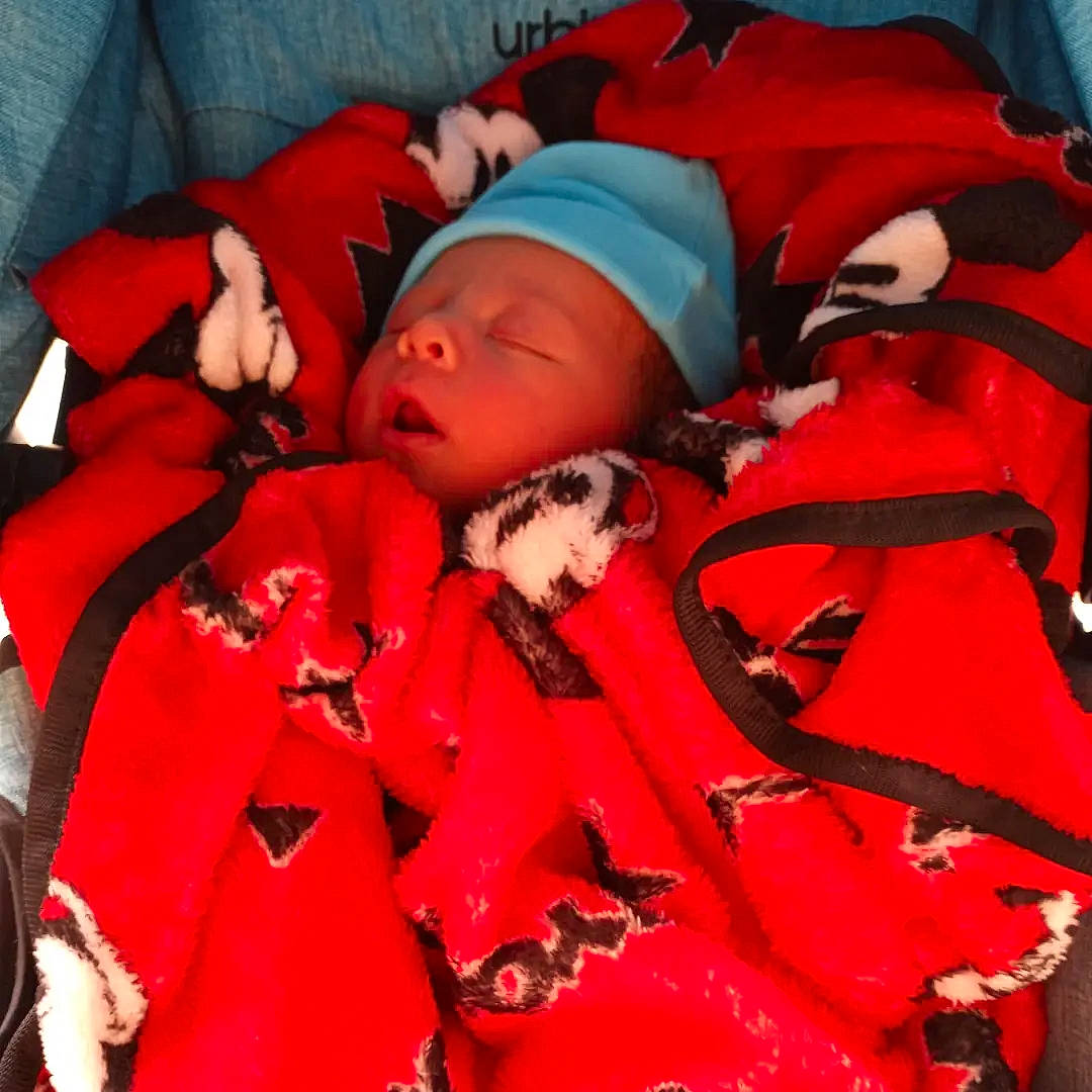 Josiah joined the competition — help win amazing prizes! baby, baby_carriage, baby_products, baby_toddler_clothing, bag, carmine, child, comfort, fashion_accessory, fictional_character, headwear, linens, magenta, orange, outerwear, person, product, room, sleeve, textile