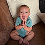 Jesse is registered to the contest to win money with this photo: baby, child, smiling, happy, indoor, couch, pillow, onesie, sitting, hands, face, blue_eyes, infant, leather, home, cute, young, portrait, clapping, furniture