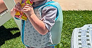 Dawson joined the competition — help win amazing prizes! child, toddler, pool, swimming_pool, sunglasses, juice_pouch, drinking, outdoor, summer, sunlight, backyard, grass, patio, poolside, life_jacket, swimwear, barefoot, chair, table, portrait