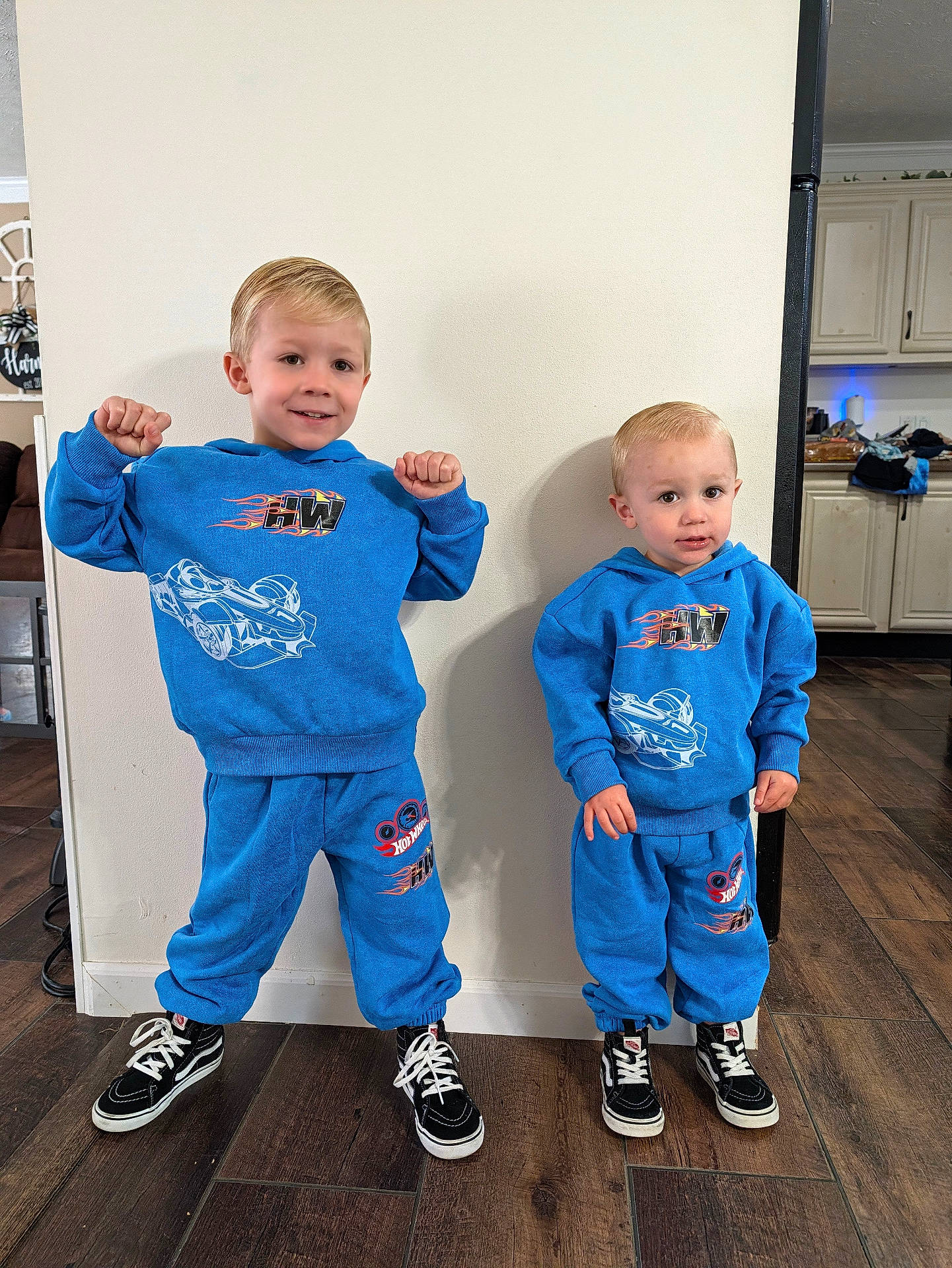 Dawson joined the competition — help win amazing prizes! blue_hoodies, boys, brothers, casual_clothing, children, family, flexing, indoor, kitchen, matching_outfits, portrait, racing_design, siblings, smiling, sneakers, standing, sweatpants, toy_cars, wood_floor, young