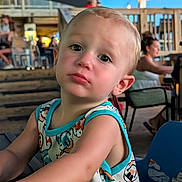 Dawson joined the competition — help win amazing prizes! toddler, child, baby, portrait, pouting, curious, face, eyes, blond_hair, outdoor, restaurant, cafe, seating, wooden_deck, string_lights, daylight, colorful_clothing, sleeveless_outfit, closeup, photography