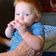 Caleb joined the competition — help win amazing prizes! baby, blue_eyes, casual, child, comfort, couch, cute, hand, holding, home, indoor, infant, messy_face, person, portrait, red_hair, seated, snack, striped_shirt, toddler