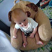 Caleb joined the competition — help win amazing prizes! baby, child, plush_chair, dog_shape, white_shirt, playpen, dinosaur_pattern, toy, infant, curious, indoor, seated, soft_furniture, baby_clothing, play_area, cute, small_feet, caucasian_baby, looking_up, home