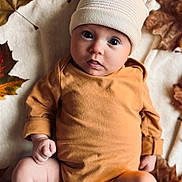 Adèle participe au concours pour gagner de l'argent avec cette photo : baby, infant, child, hat, knit_hat, brown_onesie, autumn_leaves, blanket, soft_texture, cute, wide_eyes, lying_down, indoors, seasonal, fall, cozy, portrait, baby_clothing, skin, expression