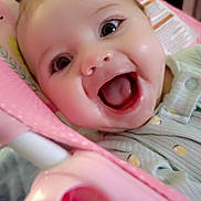 Emberly is registered to the contest to win money with this photo: baby, smiling, face, infant, pink, seat, clothing, happy, child, cute, portrait, closeup, indoor, person, expression, joy, young, baby_seat, pattern, head