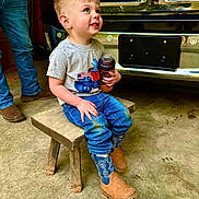 Roc joined the competition — help win amazing prizes! toddler, child, smiling, sippy_cup, jeans, boots, tshirt, wooden_stool, vehicle, chrome, grille, adult, jeans_adult, boots_adult, concrete_floor, dirt, blue_eyes, short_hair, indoor, casual_clothing