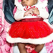 Dalylah joined the competition — help win amazing prizes! baby, infant, red_bow, red_skirt, red_socks, white_top, blanket, curly_hair, cute, festive_clothing, toddler, lying_down, indoors, portrait, child, soft_texture, colorful, clothing, headband, adorable