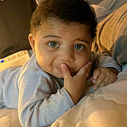 Michael joined the competition — help win amazing prizes! baby, bed, bedding, child, closeup, clothing, curious, cute, expression, face, hand, indoor, infant, light, looking, person, portrait, skin, sleepwear, young