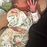 newborn, baby, infant, sleeping, hand, floral_clothing, onesie, arm, resting, soft, cozy, person, closeup, indoor, skin, peaceful, cute, toddler, child, family