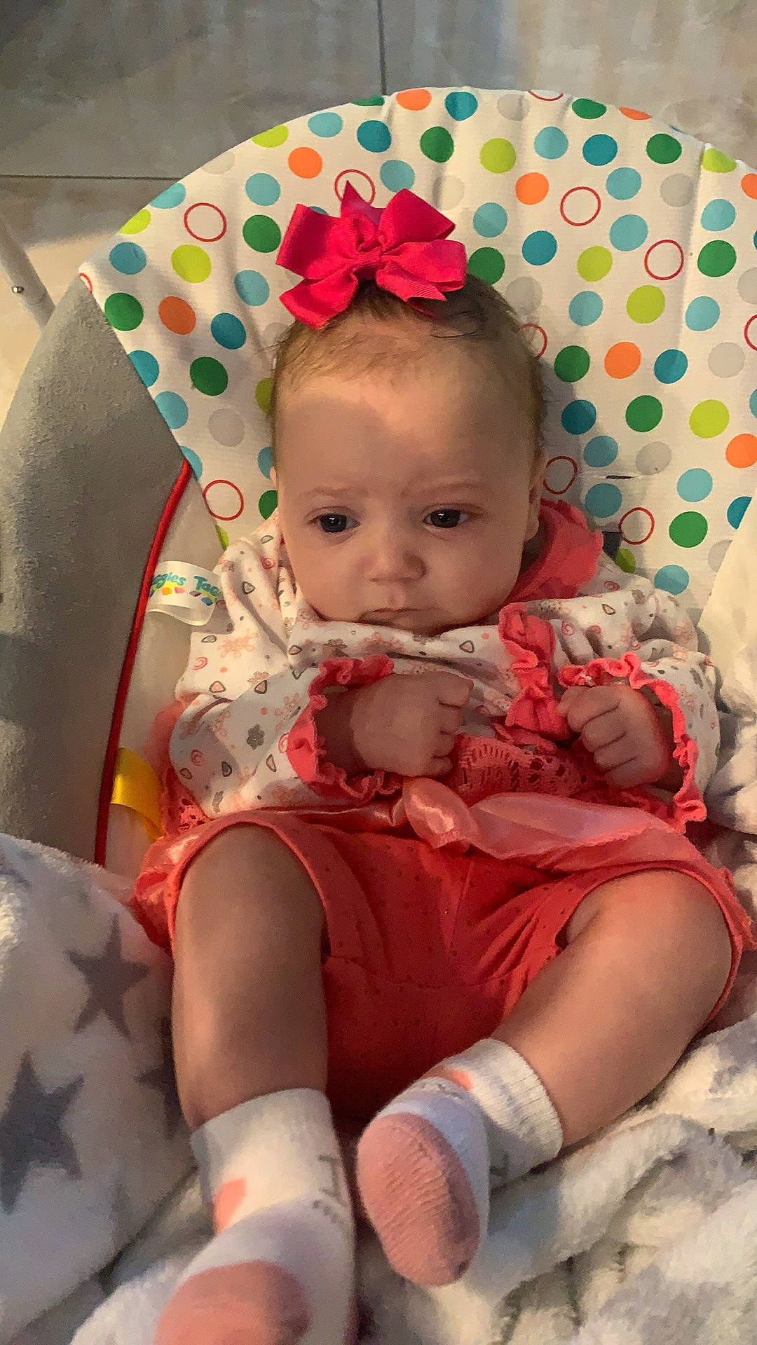 Gabrielle is registered to the contest to win money with this photo: baby, baby_toddler_clothing, cheek, child, comfort, eye, fashion_accessory, hairstyle, head, headband, human_leg, iris, lap, pattern, person, pink, product, sitting, skin, thigh