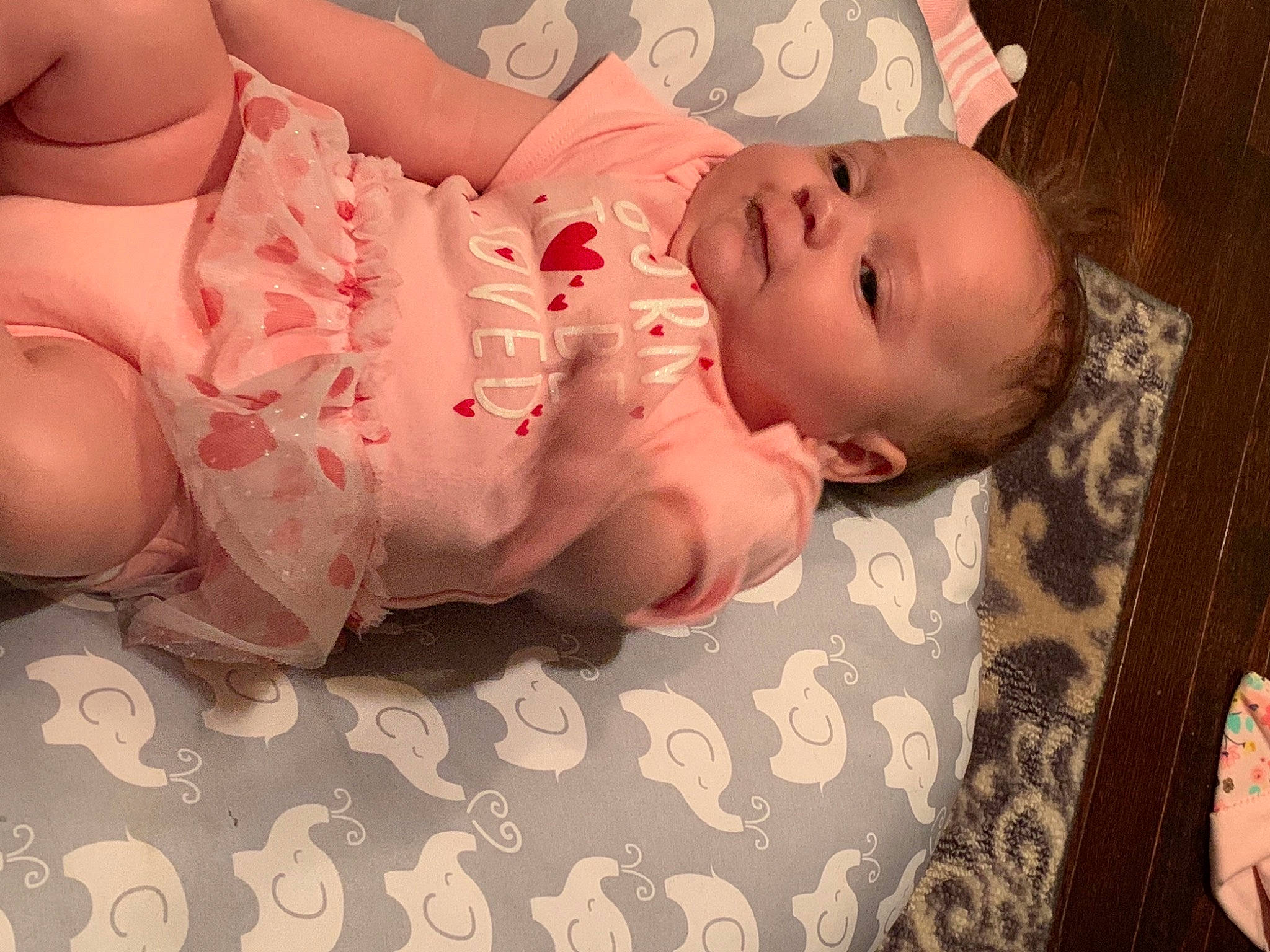 Gabrielle is registered to the contest to win money with this photo: baby, baby_toddler_clothing, cheek, child, chin, comfort, eye, face, flooring, head, leg, linens, lip, mouth, nail, nose, person, pink, skin, textile