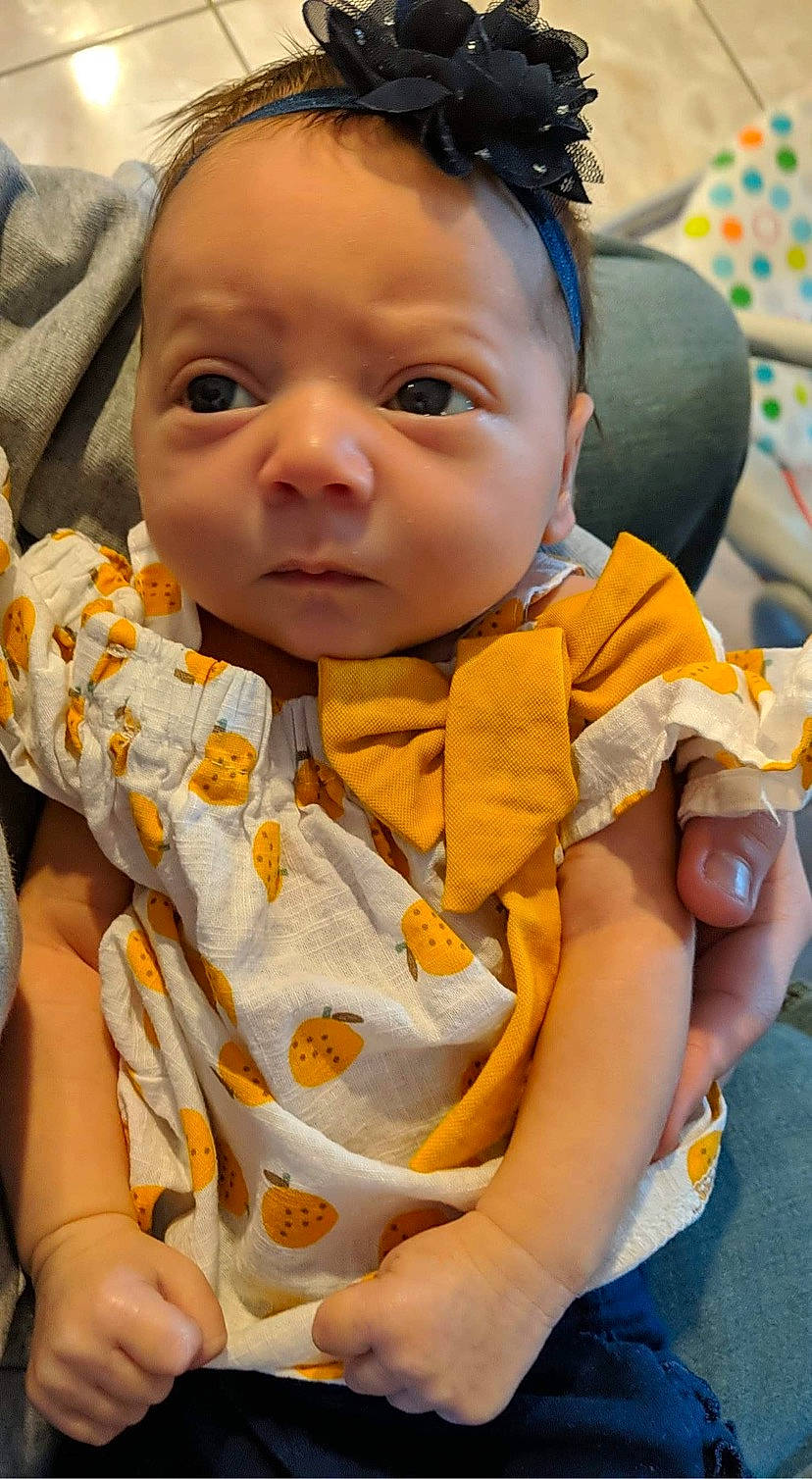 Gabrielle is registered to the contest to win money with this photo: baby, baby_toddler_clothing, cheek, child, comfort, eyelash, face, finger, grass, happy, head, iris, lip, mouth, neck, nose, orange, person, skin, sleeve