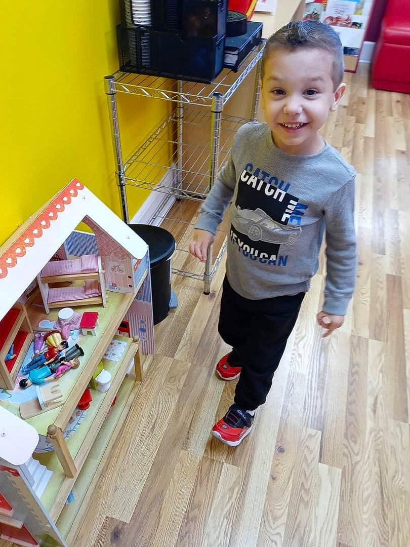 Sebastian is registered to the contest to win money with this photo: baby_toddler_clothing, bookcase, cart, child, flooring, fun, hardwood, joy, leisure, person, shelf, shelving, shopping, shopping_cart, smile, t_shirt, toddler, toy, varnish, wood