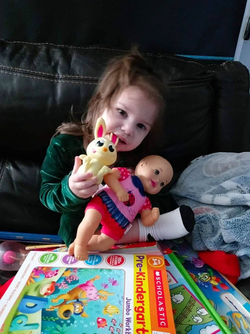 Calista is registered to the contest to win money with this photo: baby, carmine, child, comfort, doll, event, fun, indoor_games_and_sports, lap, leisure, linens, person, play, plush, recreation, room, sitting, stuffed_toy, textile, toddler