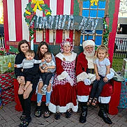 Armoni joined the competition — help win amazing prizes! child, children, santa_claus, mrs_claus, holiday, christmas, family, bench, wreath, garland, gift_box, outdoor, festive, portrait, smile, people, costume, seasonal, tree, celebration