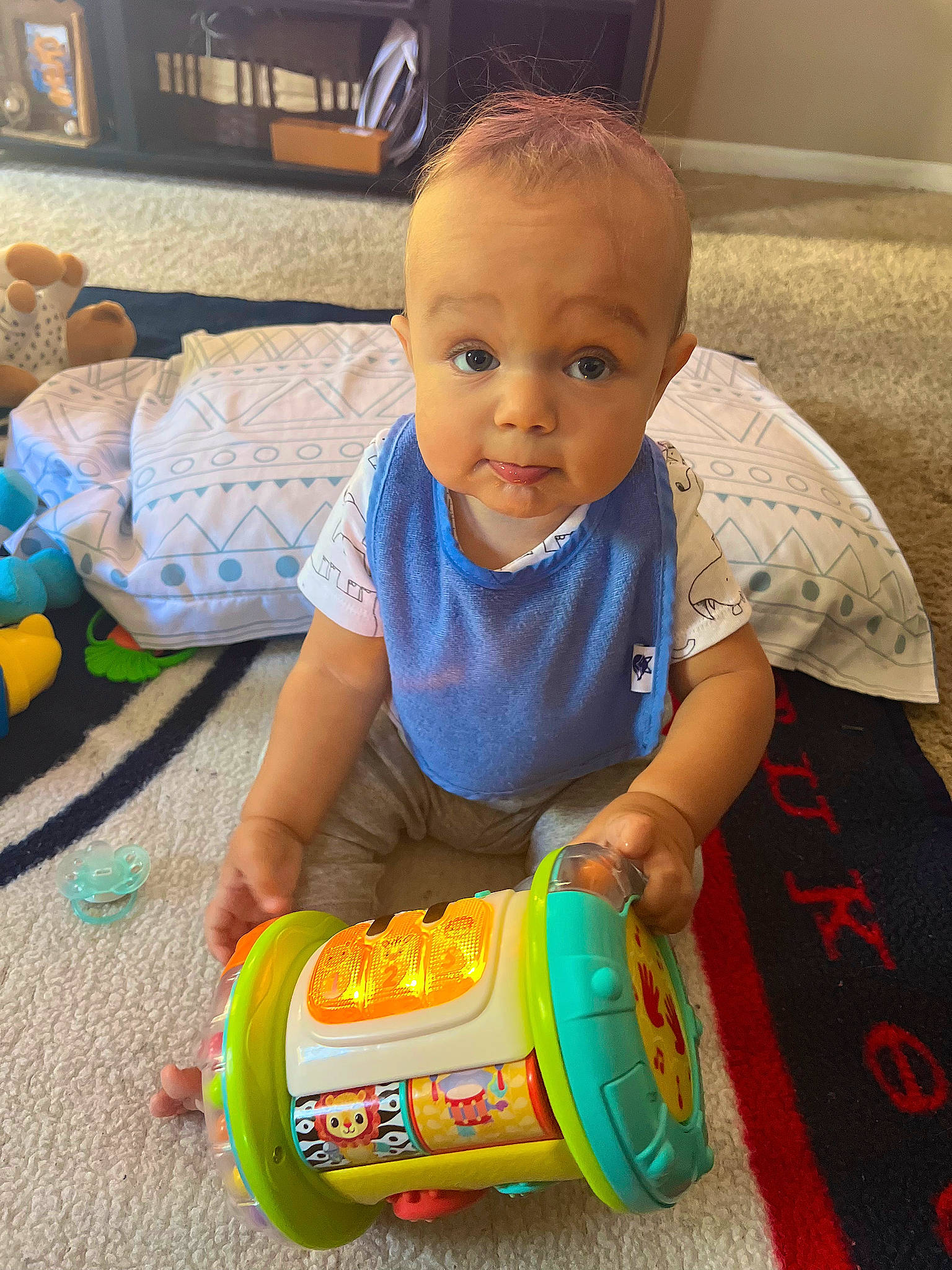 Omari is registered to the contest to win money with this photo: baby, baby_playing_with_toys, baby_products, baby_toddler_clothing, baby_toys, cheek, child, flooring, fun, happy, person, plastic, play, product, sitting, skin, smile, t_shirt, toddler, toy
