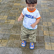 Umar Akhlaque Malik is registered to the contest to win money with this photo: boy, casual, casual_wear, child, clothing, curious, daylight, footwear, looking_down, outdoor, pavement, person, sandals, short_hair, standing, street, tiles, toddler, wet_pavement, young_child