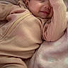 baby, blanket, child, comfort, cozy, cute, face, fingers, hand, happy, indoors, infant, lying_down, pink, relaxing, sleepwear, smile, soft, warm, zipped_jumpsuit
