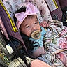 baby, baby_girl, blanket, car_seat, child, clothing, cute, face, floral_pattern, headband, indoors, infant, newborn, pacifier, person, pink_bow, portrait, resting, seatbelt, soft_light