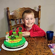 Landon is registered to the contest to win money with this photo: architecture, birthdaycake, boy, building, cake, cream, dessert, diningroom, diningtable, face, food, furniture, head, icing, indoors, person, photography, portrait, room, table