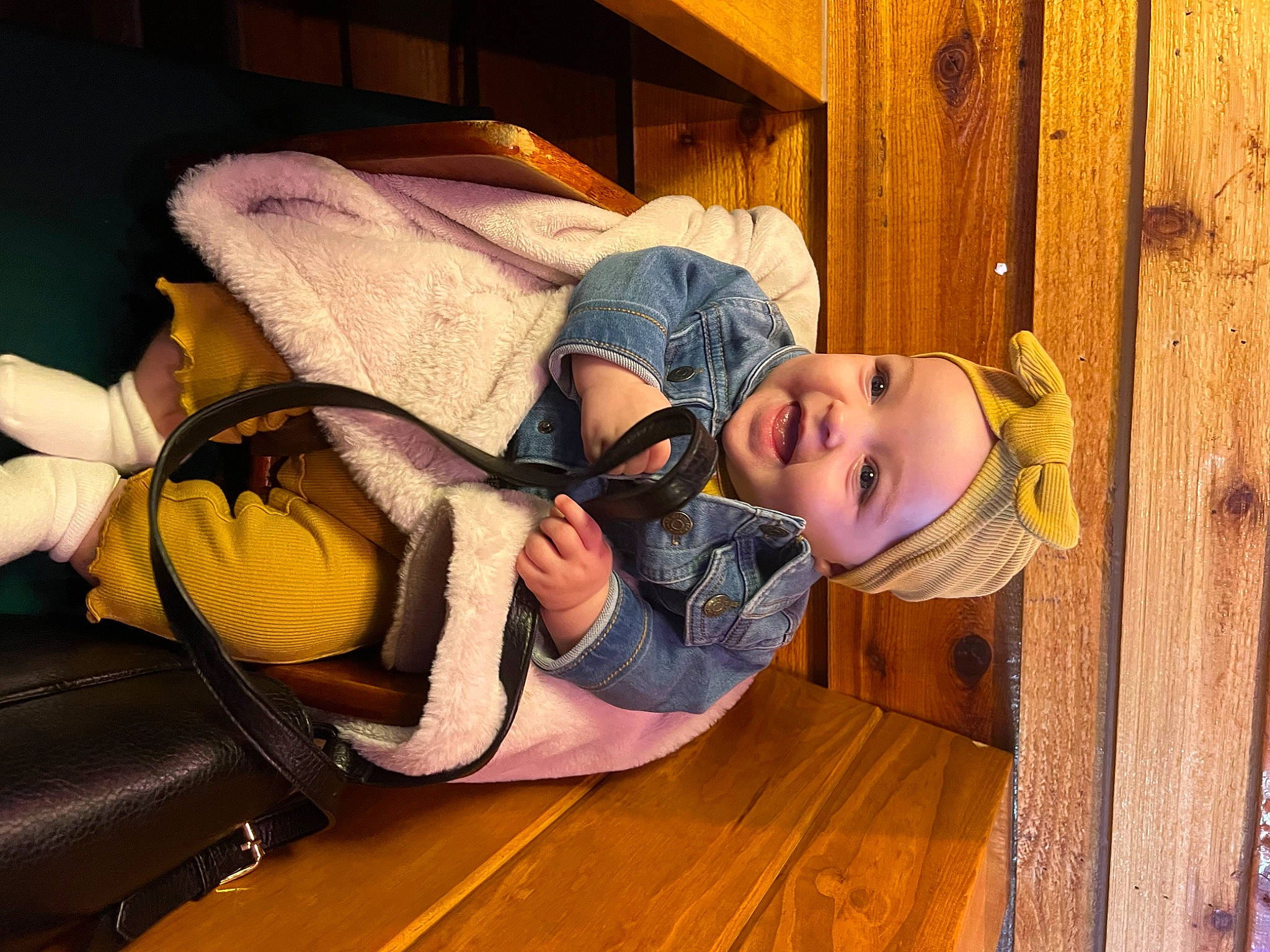 Autumn is registered to the contest to win money with this photo: baby_toddler_clothing, backpack, bag, child, comfort, flooring, fun, happy, hardwood, hat, headwear, leisure, luggage_and_bags, person, purple, room, sitting, smile, toddler, varnish