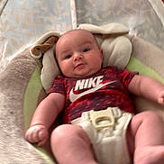 Allen joined the competition — help win amazing prizes! baby, infant, onesie, nike, baby_seat, face, legs, arms, indoor, soft_toys, comfort, cute, child, young, clothing, blurred_background, expression, skin, head, relaxing