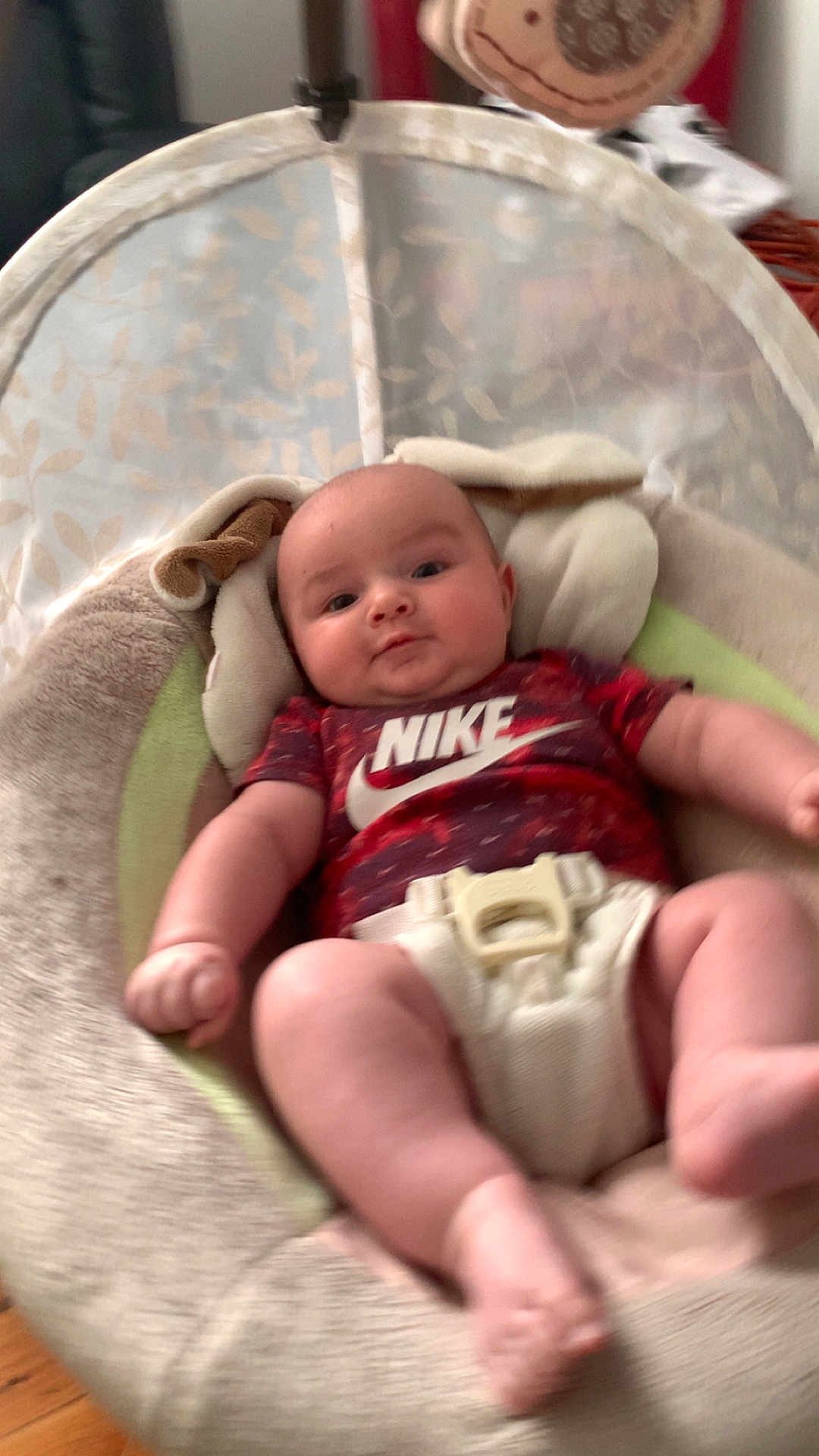 Allen joined the competition — help win amazing prizes! baby, infant, onesie, nike, baby_seat, face, legs, arms, indoor, soft_toys, comfort, cute, child, young, clothing, blurred_background, expression, skin, head, relaxing