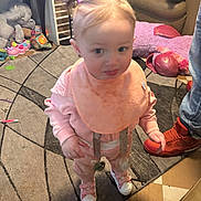 Heaven-Leigh joined the competition — help win amazing prizes! toddler, child, indoor, pink_clothing, bib, pigtails, carpet, toy, plush_toy, sneakers, person, floor, curious_expression, living_room, furniture, pacifier, cushion, shoes, standing, young_child