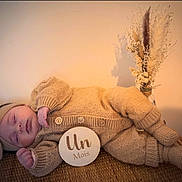 Giulia participe au concours pour gagner de l'argent avec cette photo : baby, infant, sleeping_baby, knitted_outfit, bow_headband, milestone_sign, wicker_basket, dried_flowers, pampas_grass, neutral_background, cozy, portrait, newborn_photography, beige, soft_texture, peaceful, buttons, hand, socks, laying_down