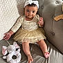 baby, child, headband, bow, dress, tulle_skirt, couch, plush_toy, elephant, knit_blanket, infant, smiling, indoor, cute, person, fabric, foot, hand, seated, home