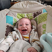 Kash joined the competition — help win amazing prizes! baby, smile, hoodie, blanket, infant, indoor, cushion, seat, happy, child, person, pattern, clothing, face, hand, fabric, comfort, cute, young, relaxation