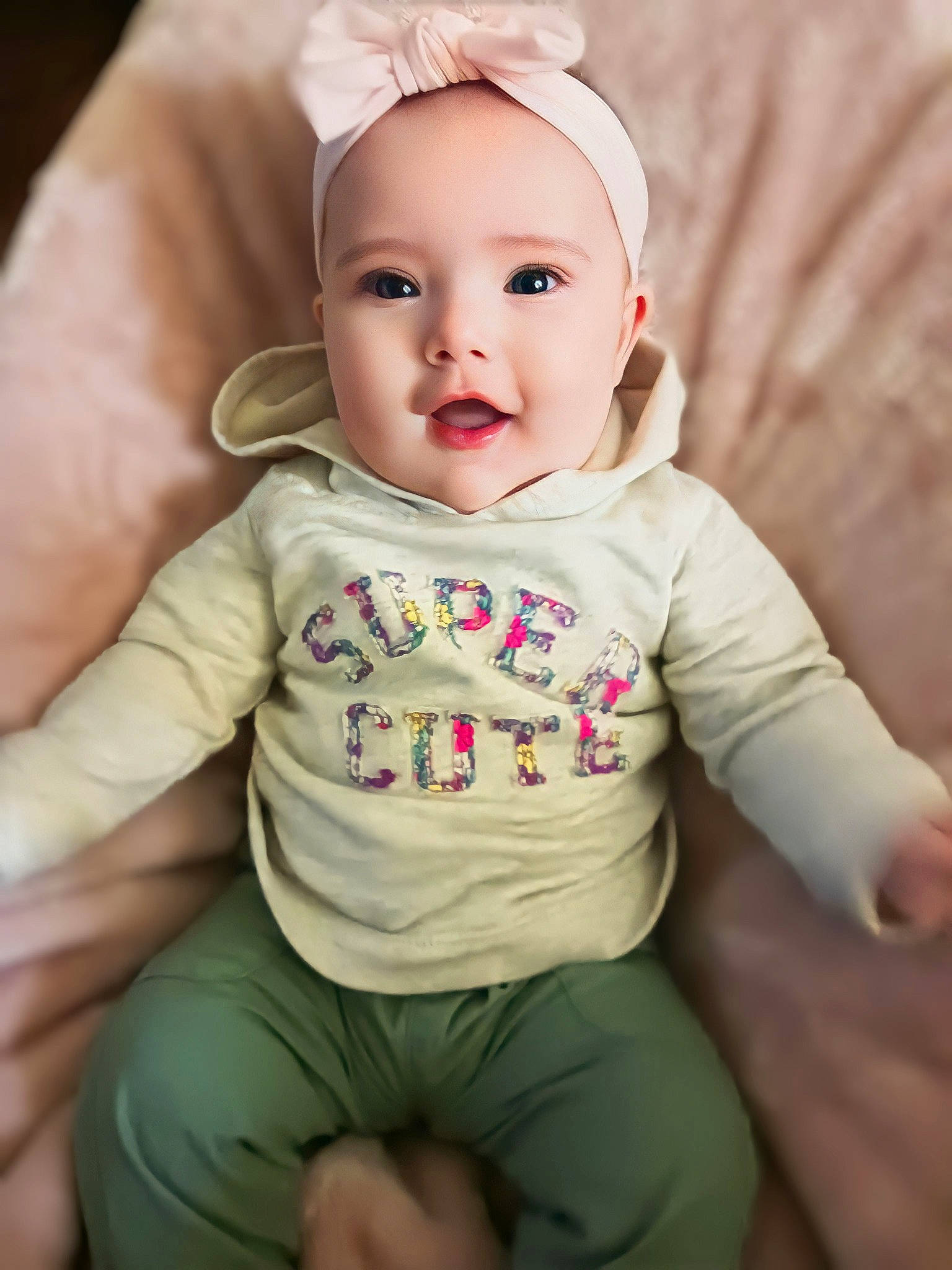 Riley is registered to the contest to win money with this photo: arm, baby, baby_toddler_clothing, cap, cheek, child, collar, comfort, eye, facial_expression, gesture, happy, hat, lip, person, pink, sitting, skin, sleeve, smile