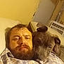 Bubba is registered to the contest to win money with this photo: beard, brown_dog, brown_hair, casual, close_up, comfort, couch, cozy, dog, expression, face, facial_hair, home, indoor, man, pet, plaid_shirt, relaxed, resting, snuggle
